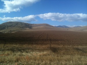 A recently plowed field with mountains in the background. 